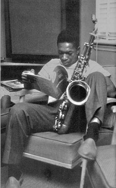 a man sitting in a chair with a saxophone