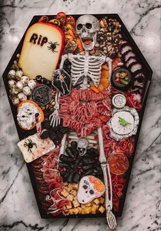 a table topped with lots of halloween food and decorations on top of a marble counter