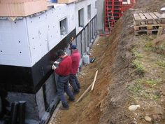 two men are working on the side of a building