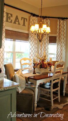 a dining room table and chairs in front of a window with the word eat on it