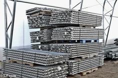 several stacks of steel bars stacked on top of each other in front of a building