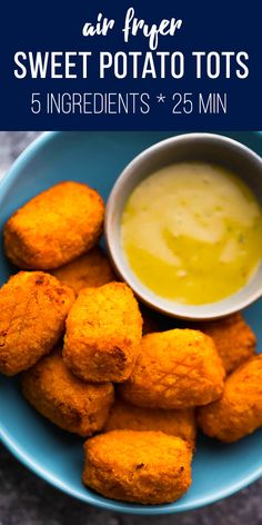 air fryer sweet potato tots in a blue bowl with dipping sauce on the side