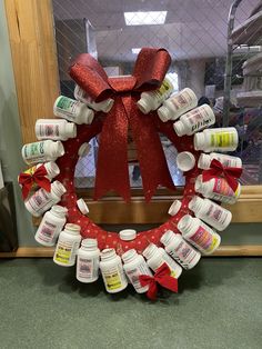 a wreath made out of bottles with a red bow