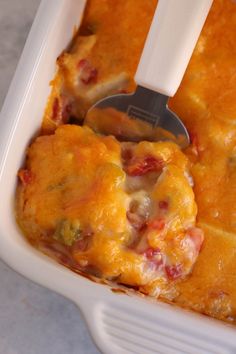 a casserole dish with meat and cheese in it is being held by a spatula