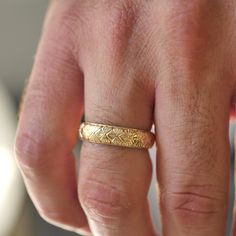 a man's hand with a gold ring on it