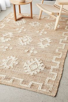 an area rug is shown with chairs and a vase on the floor next to it