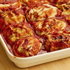 a casserole dish with meat and sauce in it on a wooden table top