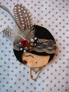 a close up of a small doll with feathers on it's head and beads in her hair