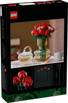 a lego box with red roses in a vase and other items on the table behind it