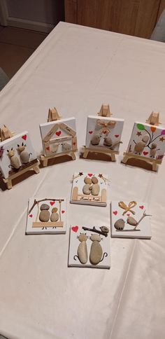 a table topped with cards and pictures on top of a white cloth covered tablecloth