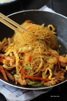 stir fried noodles with shrimp and vegetables in a wok