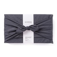 a gray headband with a large bow on the front and back side of it