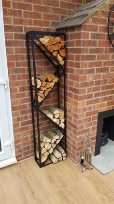 a stack of logs sitting in front of a brick wall next to a fire place