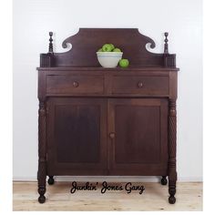 an old wooden cabinet with apples on top