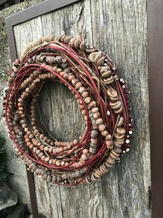 a close up of a wreath made out of wood and beads on a wooden door