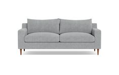 a gray couch with two pillows on it's back and one arm facing the camera