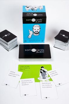 some cards are sitting on a table next to two boxes and one has a man's face