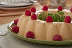 a cake with raspberries on top is sitting on a plate and ready to be eaten