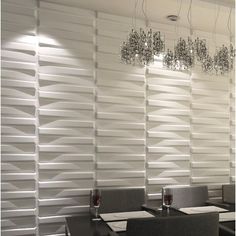 a dining room with white walls and chairs around a table that has wine glasses on it