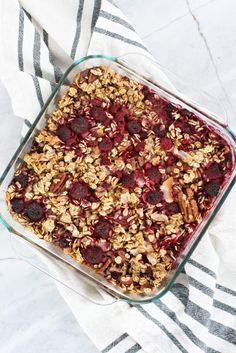 a glass dish filled with granola and fruit