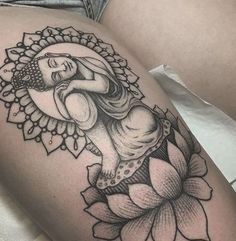 a woman's thigh with a tattoo on it and a flower in the foreground