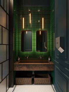 a green tiled bathroom with two sinks and mirrors on the wall, along with three lights