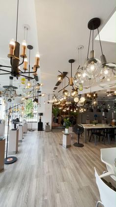 a large room with many lights hanging from it's ceiling and wooden flooring