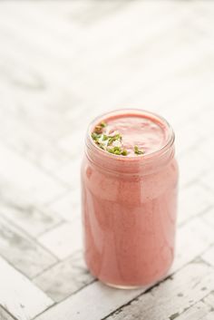 a pink smoothie in a mason jar on a table