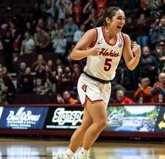 a women's basketball player running on the court