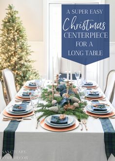 a christmas centerpiece for a long table with blue and orange plates, evergreens, pine cones and candles