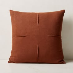 a brown pillow on a white surface