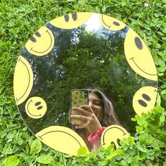 a woman taking a selfie in front of a mirror with smiley faces on it