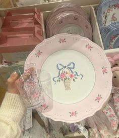 there is a pink plate with a basket on it and other plates in the background