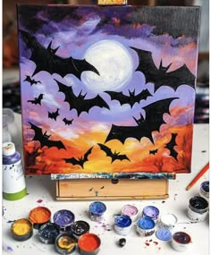 a painting with bats on it sitting next to paintbrushes