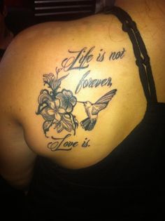 a woman with a tattoo on her back saying life is not forever love is