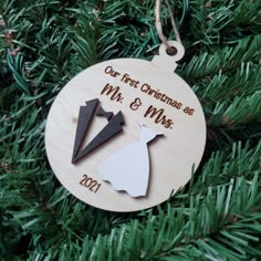 a wooden ornament hanging on a christmas tree with the words our first christmas as mr and mrs