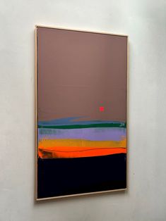 an abstract painting hangs on the wall in front of a white wall with a red dot