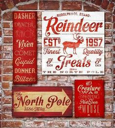 some red and white signs are hanging on a brick wall with the words north pole painted on them