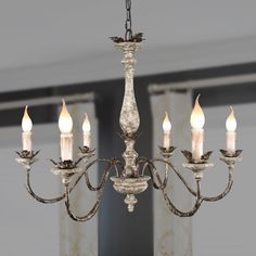 a chandelier with five lit candles hanging from it