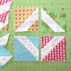 four pieces of fabric are laid out on a cutting board to make a quilt block