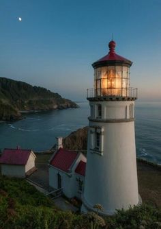 a light house sitting on top of a hill next to the ocean