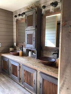 a bathroom with two sinks and large wooden cabinets in front of the mirror on the wall