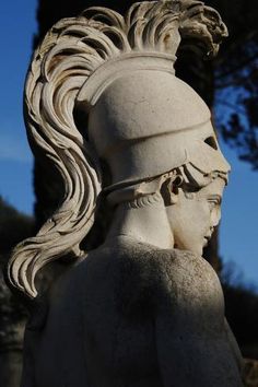 a white statue with long hair wearing a headdress on it's face