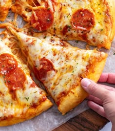 a person is taking a slice of pizza from a platter with cheese and pepperoni