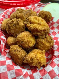 some fried food sitting on top of a red and white checkered paper