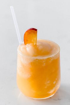 an orange drink in a glass with a straw