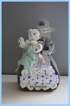 a teddy bear is sitting on top of a baby's diaper cake with stars