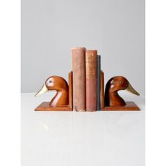 two wooden ducks sitting on top of books