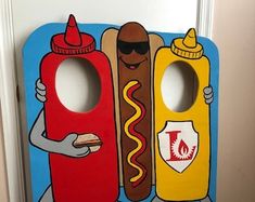 a door hanger with two hot dogs and ketchup