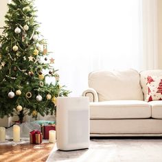 a living room with a christmas tree and a white couch